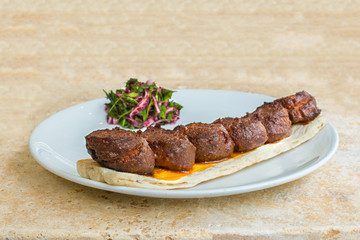 Grilled turkish sausages kebab also known as sucuk with vegetables on white plate