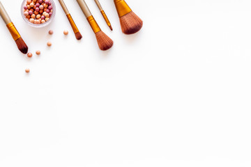 Women desk with brushes and blusher for make up on white background flat lay space for text