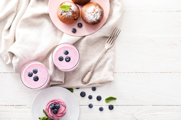 Fototapeta na wymiar Tasty desserts with blueberry and yogurt on white table