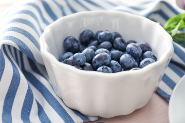 Bowl with fresh blueberry on table