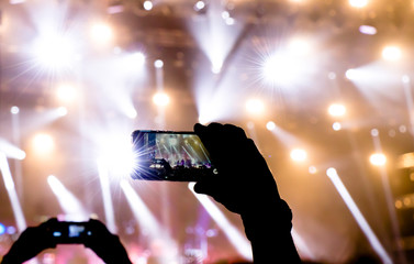 Fototapeta na wymiar Silhouette of people shooting the concert event with mobile phones