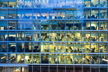 working late: illuminated office spaces in a modern building in the evening - 277260903