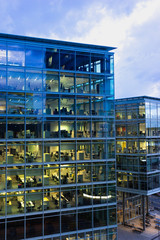working late: illuminated office spaces in a modern building in the evening - 277260907