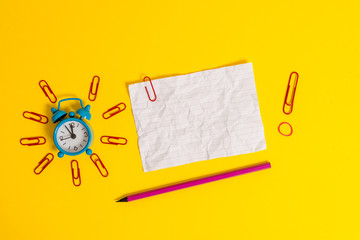 Metal alarm clock clips crushed sheet pencil rubber band colored background