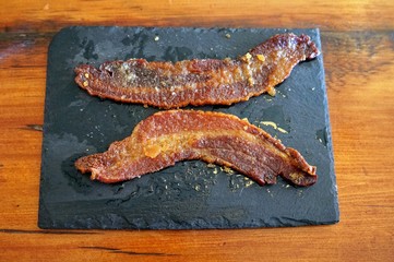 Two Slices of Country Bacon on a Slate Plate