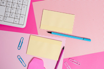 Writing equipments and computer stuffs placed above colored plain table