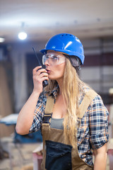 young woman worker using radio communication device