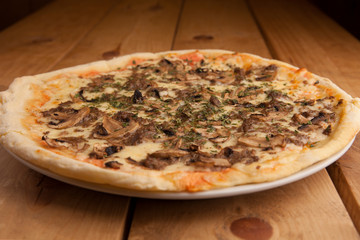 Delicious mushroom pizza on a wooden table.