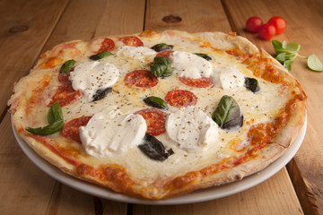 Delicious mozzarella pizza on a wooden table.