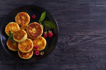 Cottage cheese pancakes. Syrniki and raspberries. View from above, top studio shot