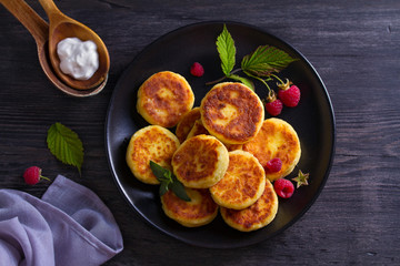 Cottage cheese pancakes. Syrniki and raspberries. View from above, top studio shot