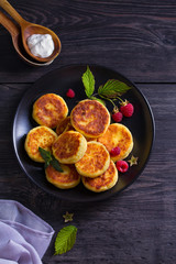 Cottage cheese pancakes. Syrniki and raspberries. View from above, top studio shot