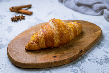 The classic croissant on the board on grey concrete background