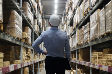 Double exposure of man with interior of warehouse. Rows of shelves with boxes for logistic network distribution on background and Logistics Industrial  for shipping and Transportation, import-export