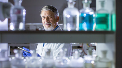 Senior male researcher carrying out scientific research in a lab (shallow DOF; color toned image)