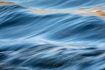 Gordijnen Water concept - river water flowing with light reflecting of its surface - long exposure shot © lightpoet