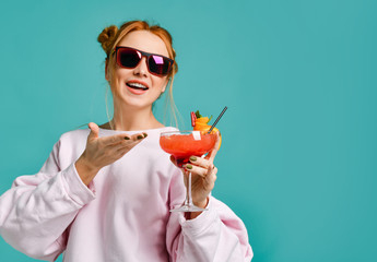 Bartender woman in red sunglasses shows demonstrates offers excellent strawberry margarita cocktail 