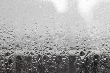 Fototapeta na wymiar water drop on glass with backdrop blurred. dark tone