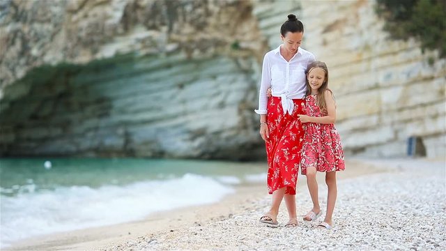 Beautiful mother and daughter on the beach