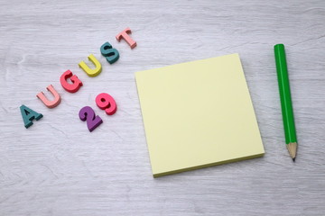 August 29 - Daily colorful Calendar with Block Notes and Pencil on wood table background, empty space for your text or design