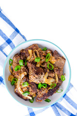 Fried liver with onions in bowl on white background.