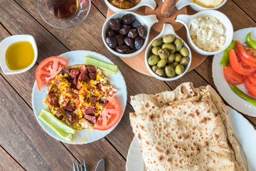 Traditional Turkish Breakfast Table. Turkish Breakfast Food Cuisine Culture. Turkish pide yufka ekmek, tea, bagel, borek, sikma, cheese, olives, oil and honey on wooden table from top view.