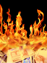 Conceptual finance image of burning pile of money, dollar and euro bills, with fire flames in black background