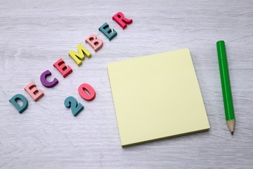 December 20 - Daily colorful Calendar with Block Notes and Pencil on wood table background, empty space for your text or design