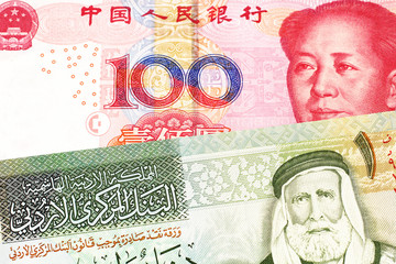 A Chinese renminbi one hundred yuan bank note with a one dinar bill from Jordan, close up in macro