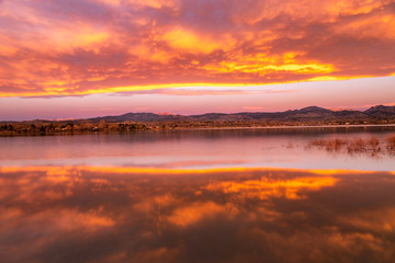 Colorful Sunrise or Sunet reflecting in a lake along the Colorado Mountain Front range