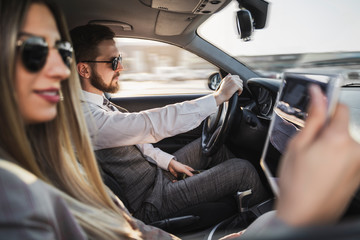 Handsome man driving a car , woman on passenger seat  