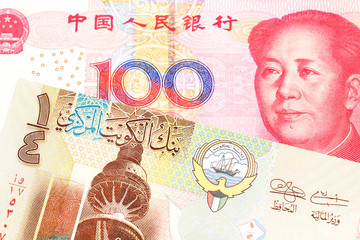 A one quarter dinar from Kuwait close up with a red Chinese renminbi one hundred yuan note in macro