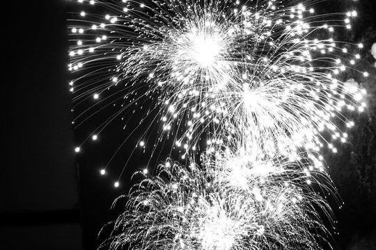 Black and white close up photo of fireworks in the night sky