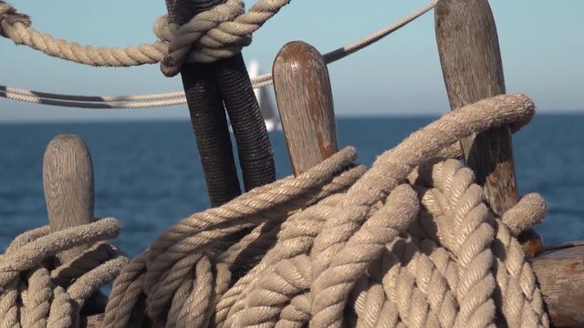Deck organizer wish pin and the ropes of old sailing ship at sea. Slow motion video.