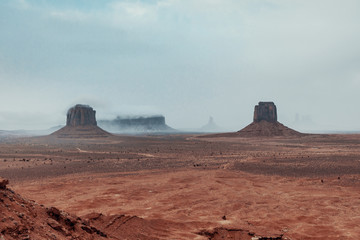 Fototapeta na wymiar the mountains of monument valley under the snow and in the fog. 