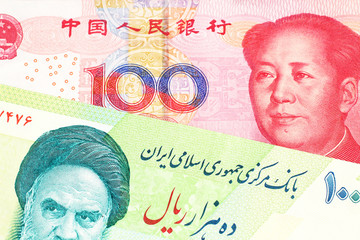 A close up image of a green Iranian ten thousand rial bank note with a red, one hundred yuan Chinese renminbi note in macro