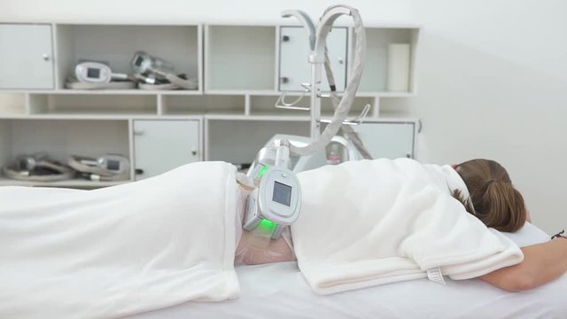 cryolipolysis, a woman is lying on the table during a procedure in a beauty parlor or spa center