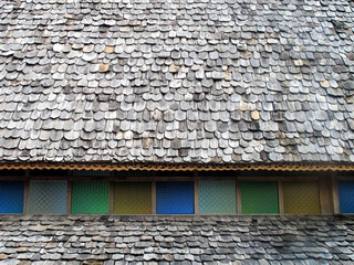 close up traditional asian roof top of building with wooden roof tiles in Phuket island, Thailand