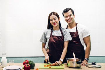 Happy couple cooking and preparing meal together in the kitchen