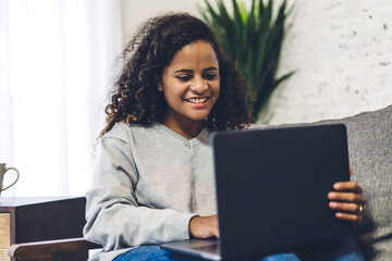 Young african american black woman relaxing and using laptop computer.woman checking social apps and working.Communication and technology concept