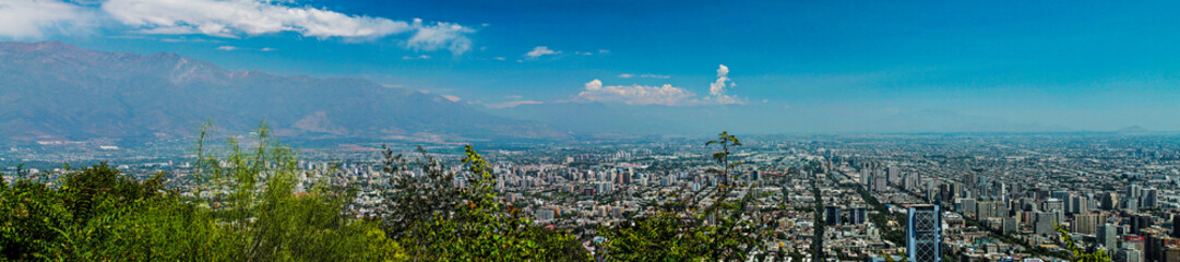 Panoramic view of Santiago, Chile, from Cerro San Cristóbal on a sunny day, showcasing the city's modern skyline and vibrant urban landscape under clear skies