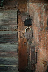 Old wooden door locked by 2 padlocks