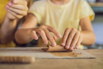mother and son doing ceramic pot in pottery workshop