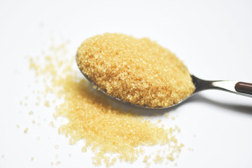 brown sugar in a spoon on white background
