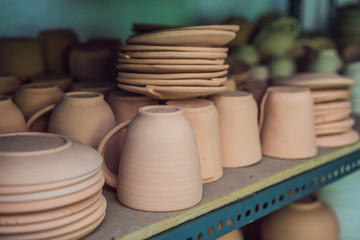 Fototapeta na wymiar Cups on the shelves in the pottery workshop
