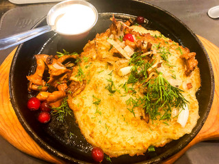 Potato pancake with mushrooms in pan