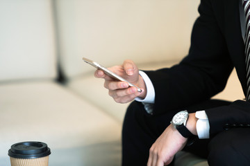 スマートフォンを操作するビジネスマンの手元