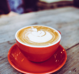Closeup latte art coffee red cups in a cafe