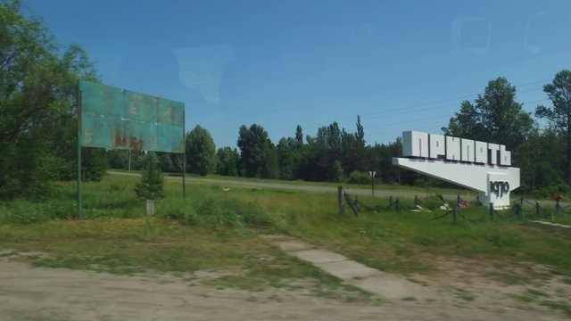 Driving by historical sign at the entrance to Pripyat, site of the catastrophic nuclear disaster that is a continuing environmental and ecological issue