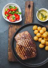 Grilled beef steaks with spices on black plate